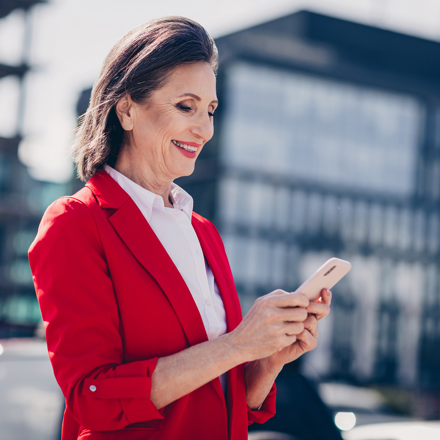 Women in red jacket outside on phone.