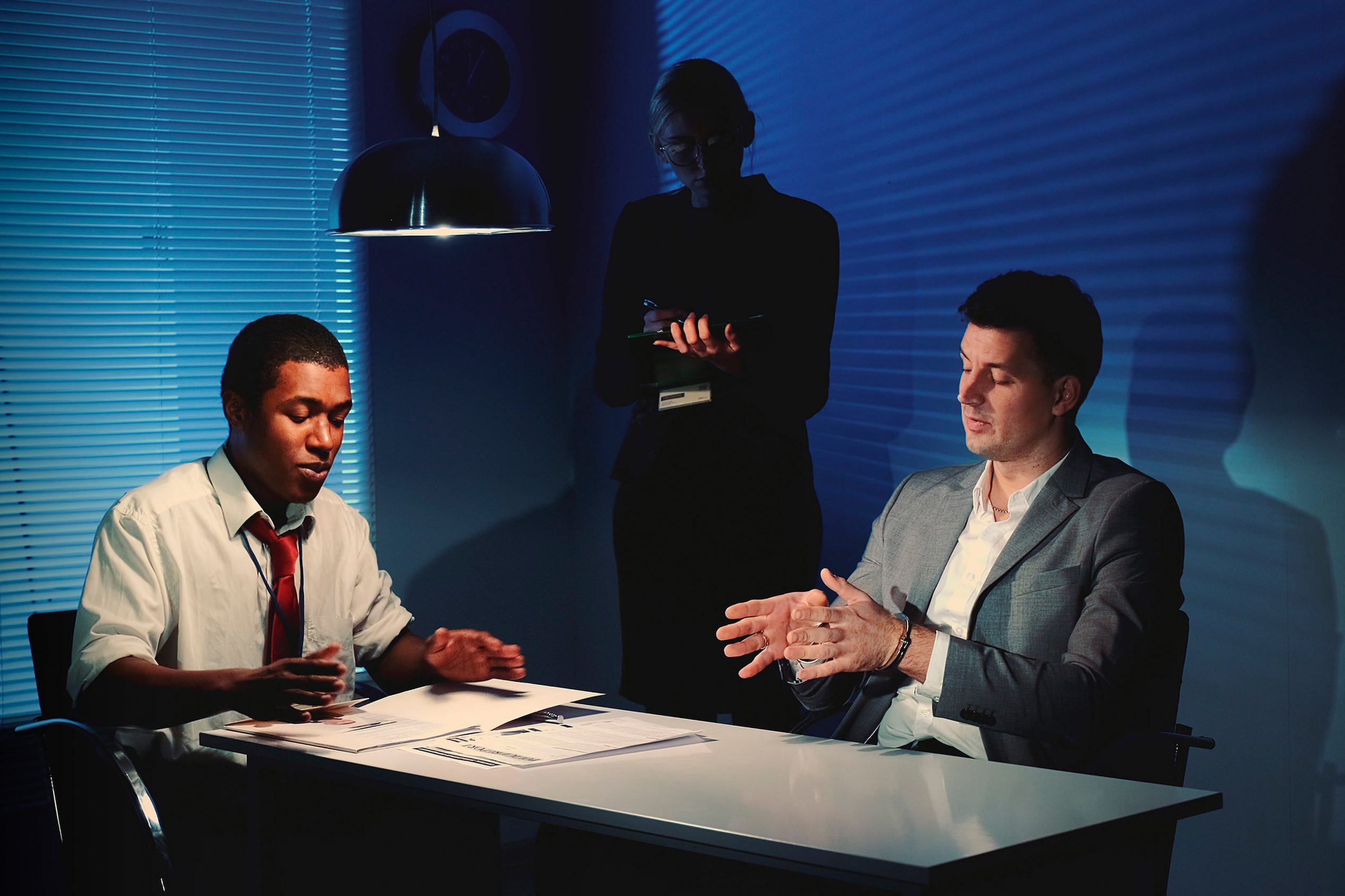 Man in handcuffs being interviewed by police
