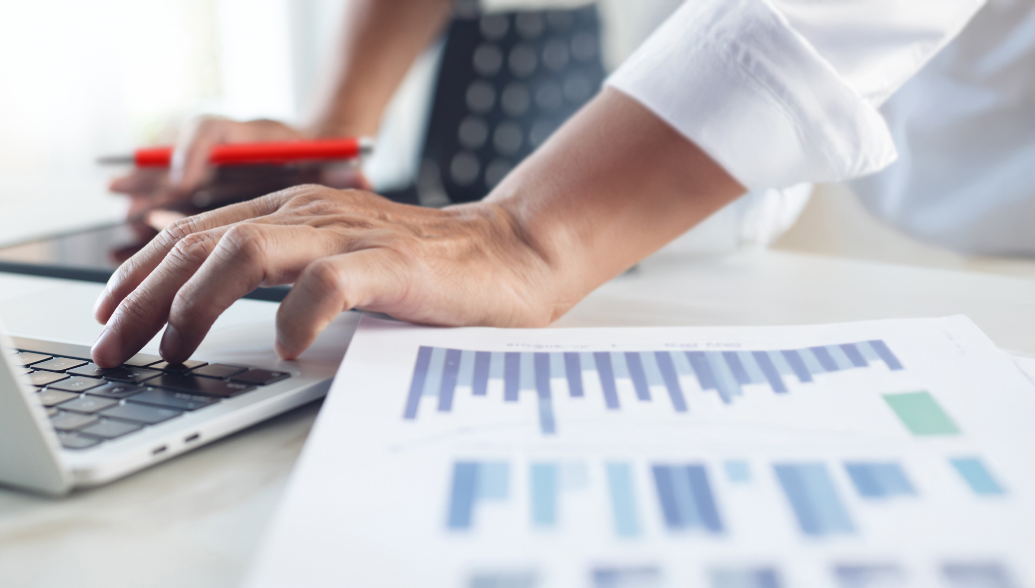 Individuals are typing amid spreadsheets