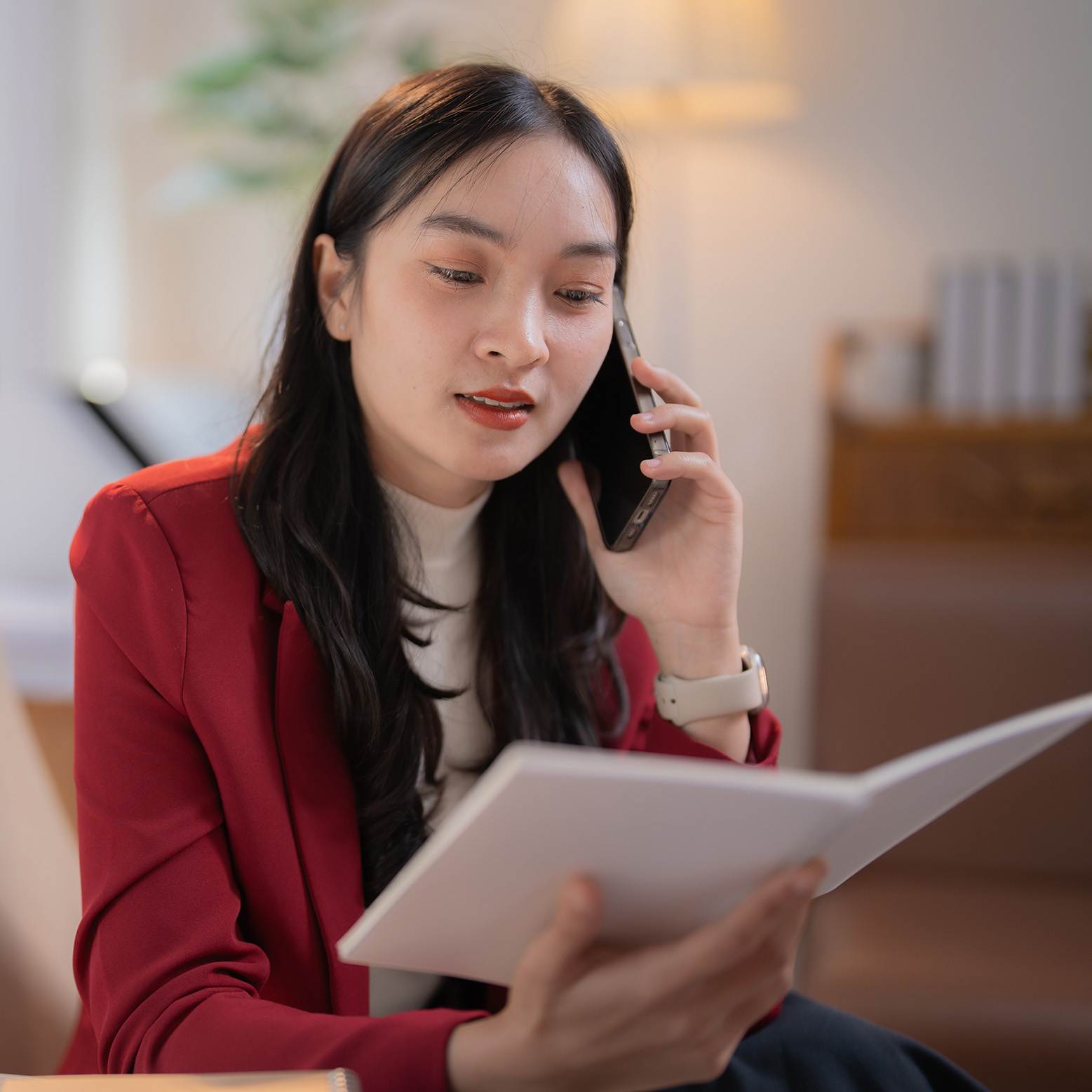 Woman reading a report while talking on the phone