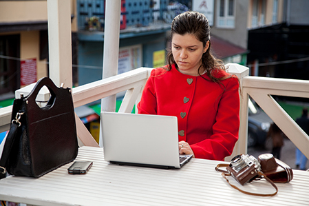 Middle Eastern woman sitting outside with a laptop