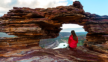 Woman in Outback sitting under rocks