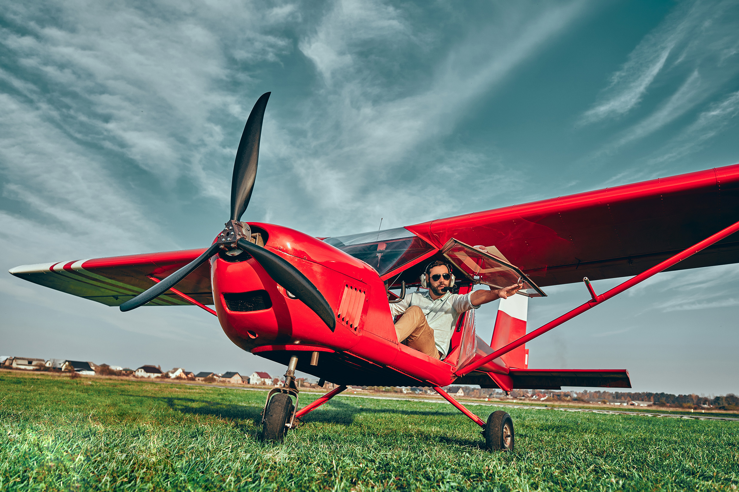 Red airplane with a pilot in a field